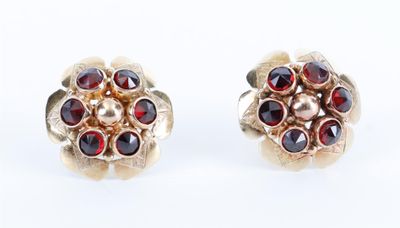 une paire de boucles d'oreilles ornées de grenats rouges sur fond blanc