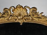 a large mirror with a gold frame and a black background