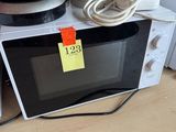 a microwave with a yellow sticker on it sitting on top of a counter