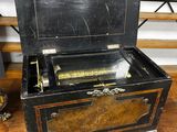 an old fashioned musical box sitting on a wooden table