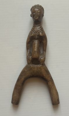 une petite figurine en bois posée sur une table
