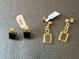 trois paires de boucles d'oreilles posées sur un support en cuir noir