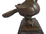 statue d'un oiseau posée sur un socle en marbre, sur fond blanc