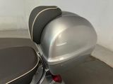 a silver motorcycle parked in a garage with a black seat