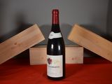 a bottle of wine sitting on a table next to two wooden boxes