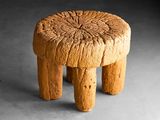 une image représentant un petit tabouret en bois posé sur une surface grise