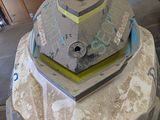 a concrete sculpture of a tank sitting on top of a rock