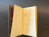 an open book sitting on top of a table next to a red rug