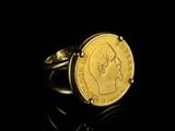 a close up of a gold coin ring on a black surface