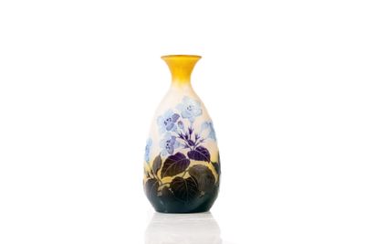 a yellow vase with blue flowers on it sitting on a white surface