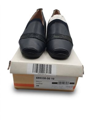 une paire de chaussures en cuir noir posée sur une boîte portant un code-barres sur le côté