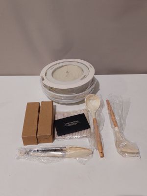 une table blanche sur laquelle se trouvent un bol, un pinceau et d'autres objets