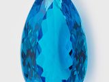 une topaze bleue en forme de larme, facettée, sur fond blanc