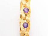 un gros plan d'une bague en or sertie de pierres violettes
