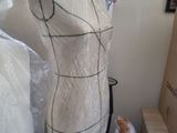 a mannequin on a stand with plastic wrap around it
