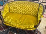 an image of a yellow couch sitting on top of a rug in a room