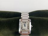 une photo d'une montre en argent posée sur une serviette verte