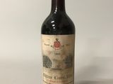 an old bottle of wine sitting on top of a white table