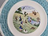 a plate with a picture of people and animals on it