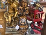 a gold statue of a boy and a girl sitting on a table