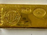 a close up of a gold bar on a white surface