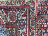 a close up of a red and blue oriental rug with a blue background