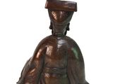 bronze figurine of a woman with a hat on her head