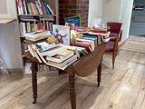 une table sur laquelle sont posés de nombreux livres, dans une pièce