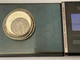 a silver coin sitting on top of a digital scale