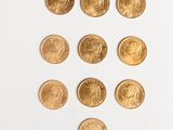 several gold coins arranged in a triangle on a white surface