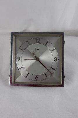 une horloge en argent posée sur un drap blanc