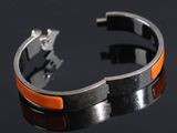an orange and black bracelet on a black surface with a black background