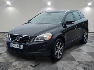 Le SUV Volvo noir est garé dans une grande pièce.