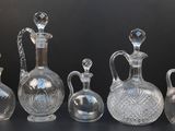 cinq vases en verre posés sur une table devant un fond noir
