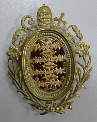 an image of a gold and red broochle with a crown on it