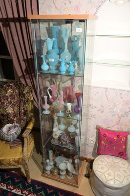 une vitrine dans un coin de la pièce, avec une chaise et un tapis