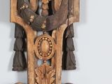 a wooden clock that has a bird on top of it