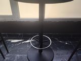 une petite table et deux chaises devant une fenêtre