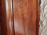 a wooden armoire in the corner of a room