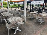 de nombreuses tables et chaises disposées sous des parasols