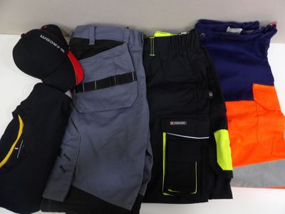 cinq paires de pantalons de ski et un bonnet posés sur une table