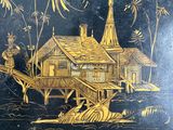 a black and gold tray with a picture of a house on it