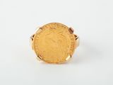 a close up of a gold coin ring on a white surface