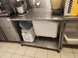 a metal shelf with a bin and a mixer on it