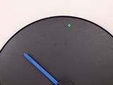 a black clock with a blue second hand and a green second hand