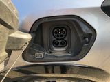 a close up of a car with an electric charger plugged into it