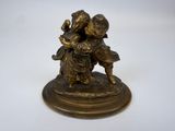 figurine antique en bronze représentant un garçon et une fille tenant un panier