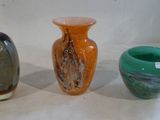 trois vases de couleurs différentes posés sur une surface blanche