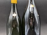 two bottles of wine sitting next to each other on a table