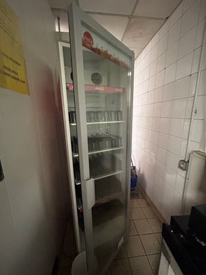 un réfrigérateur dans un coin de la cuisine, muni d'une porte vitrée
